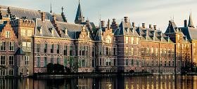 Foto in Den Haag waarbij een fontein in een meer is te zien met woonruimtes op de achtergrond