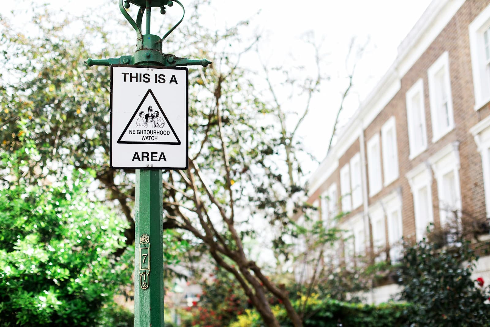 Een paal met daaraan een bordje met de Engelse vertaling van buurtpreventie Een paal met daaraan een bordje met de Engelse vertaling van buurtpreventie