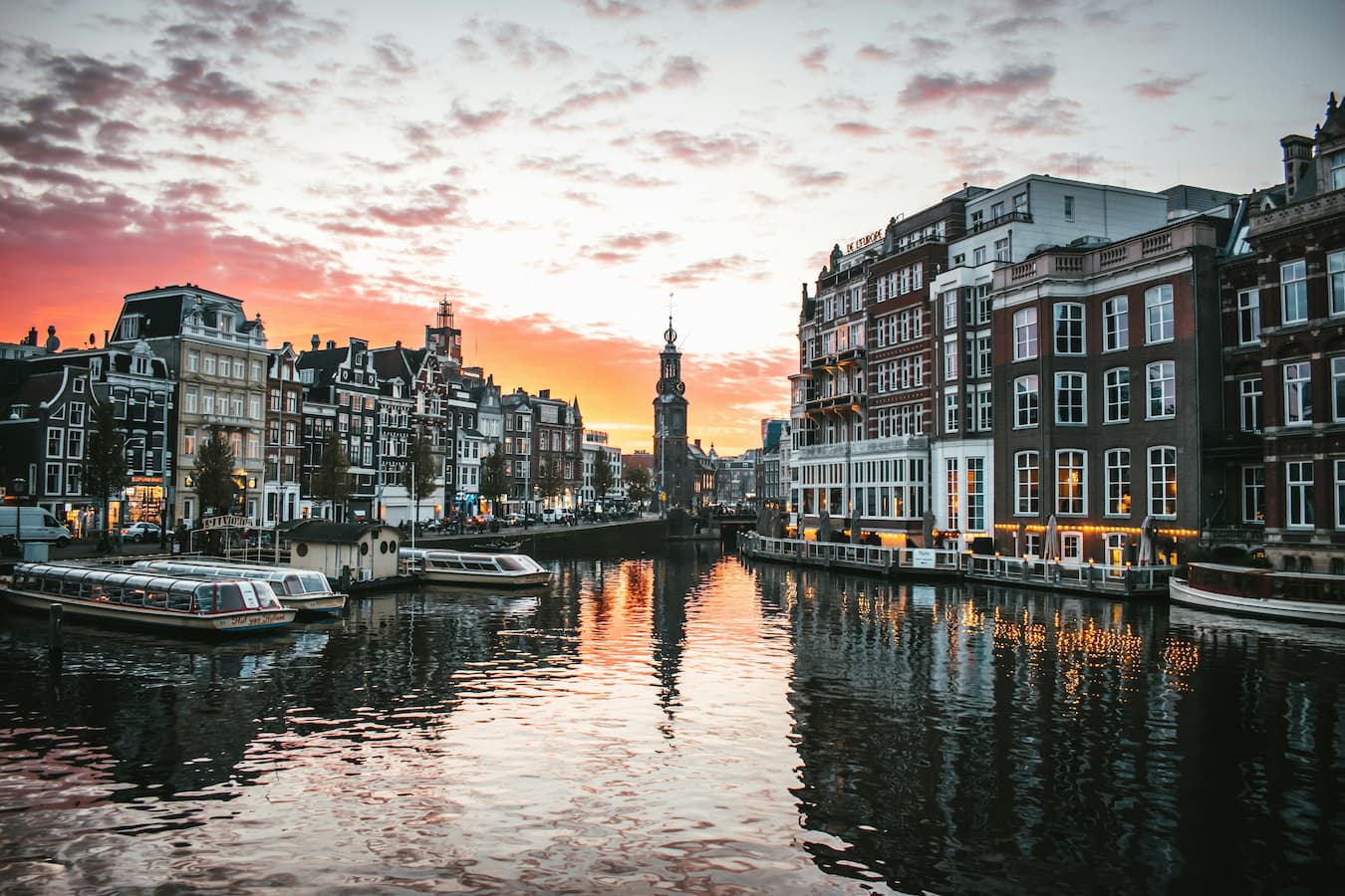 De grachtenpanden en grachten van Amsterdam tijdens een zonsondergang De grachtenpanden en grachten van Amsterdam tijdens een zonsondergang