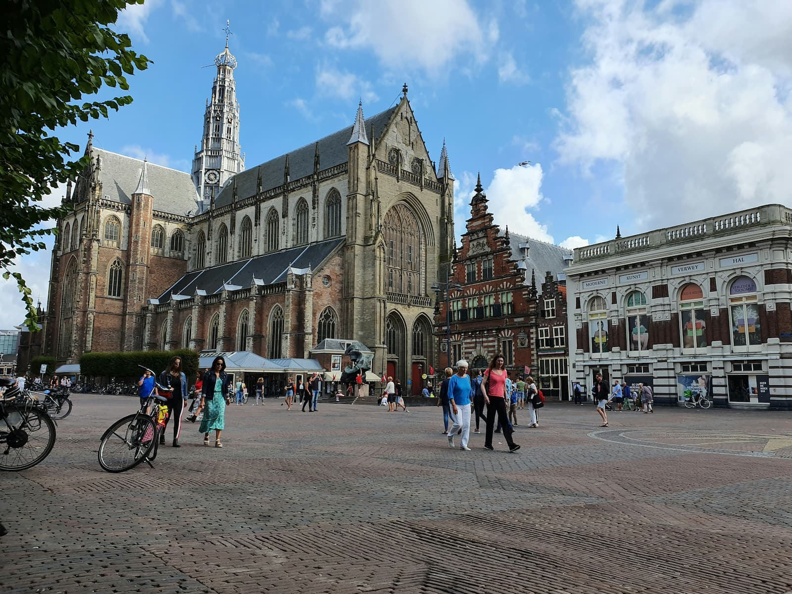De Grote Markt van Haarlem met verschillende groepjes mensen die over het plein wandelen.