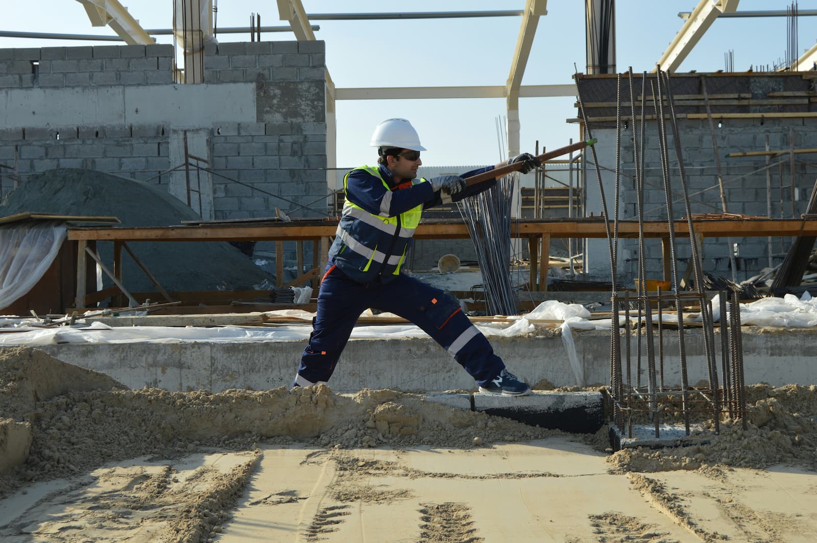 Een bouwvakker is bezig met het bouwen van nieuwe huurwoningen op een constructieplek