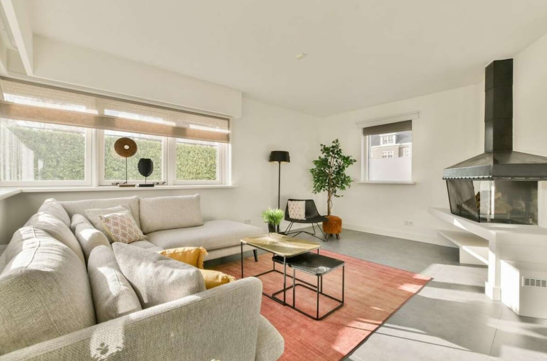 Interieur van een villa met een haard en een witte bank Interieur van een villa met een haard en een witte bank