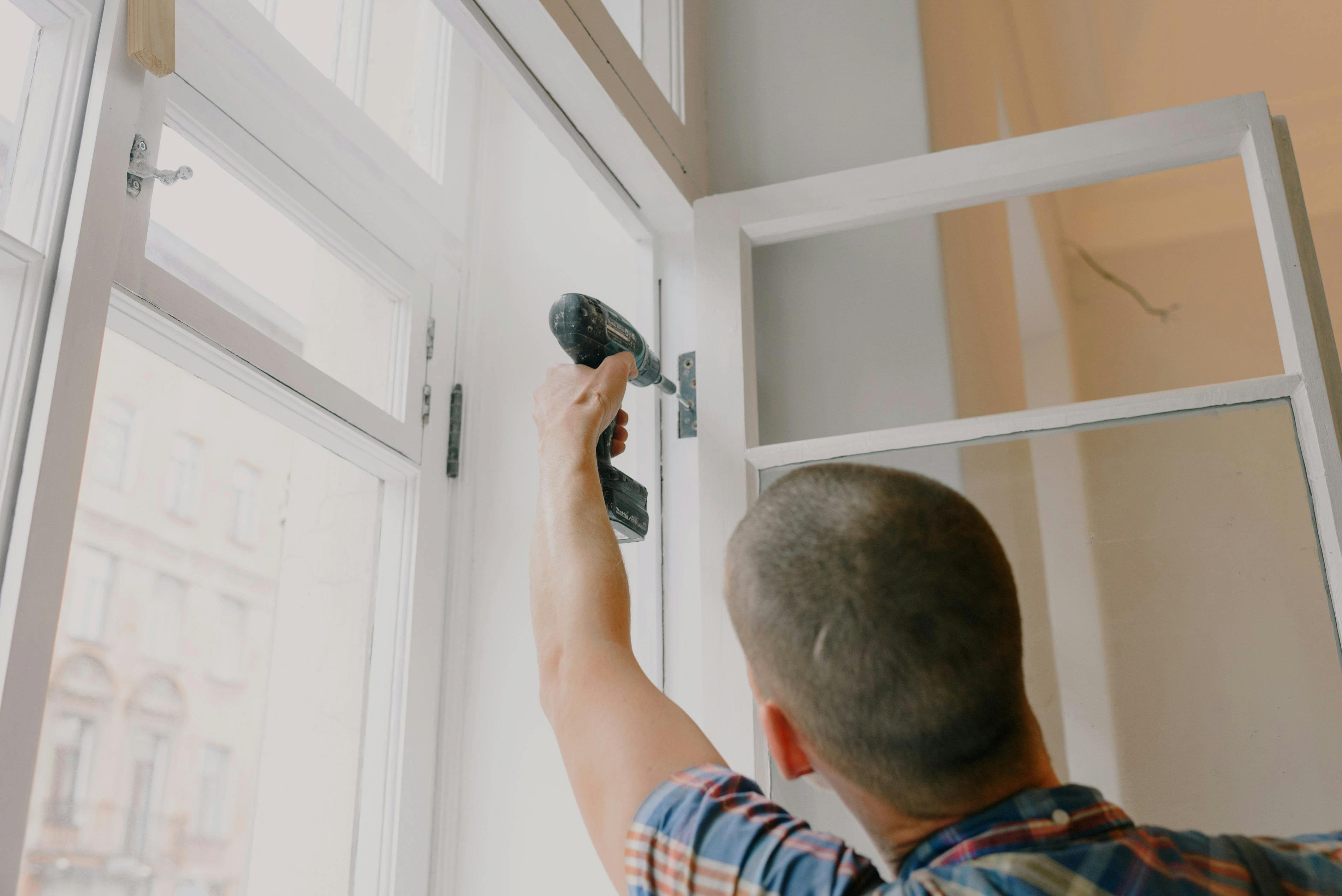 Man isoleert woning door raam te plaatsen Man isoleert woning door raam te plaatsen