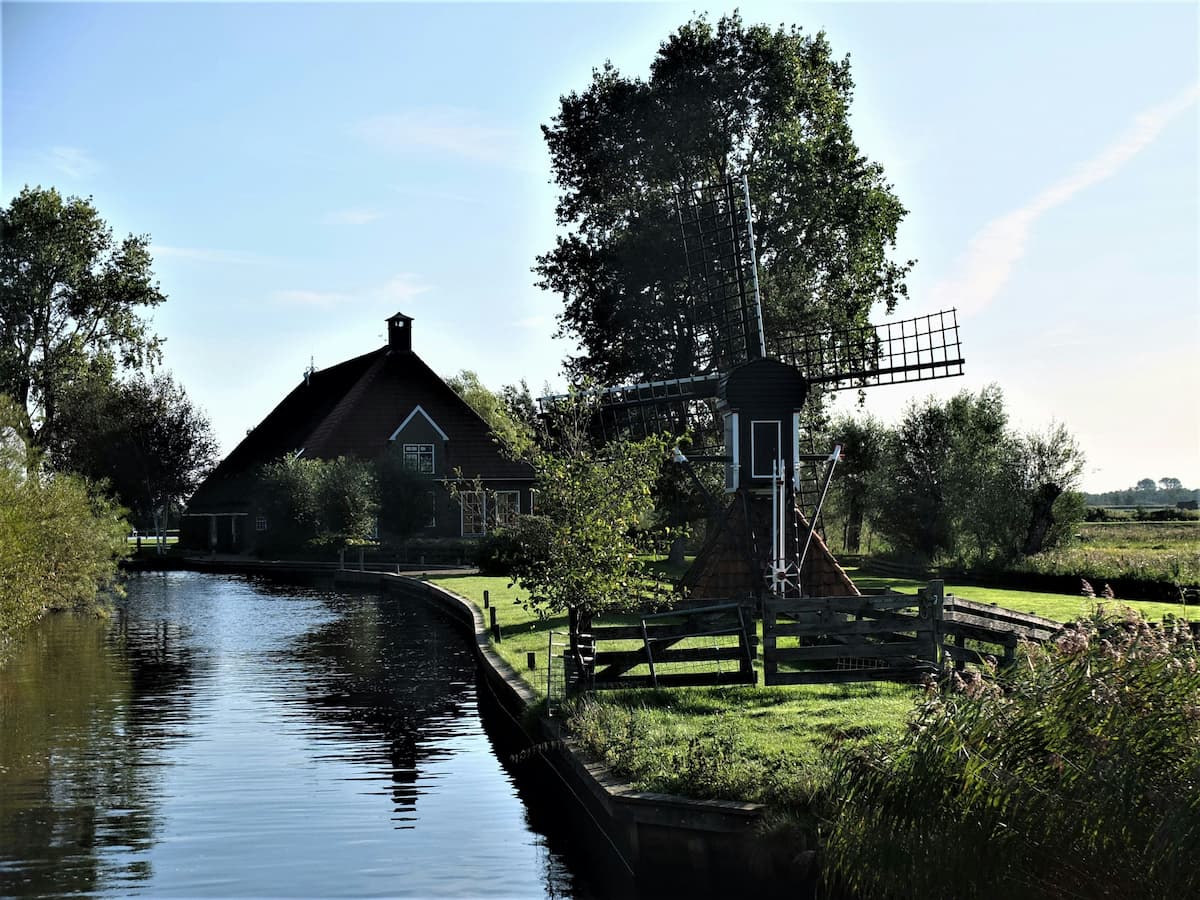Een mooi huis op het Friese platteland omringd door veel groen met een kleine molen op de voorgrond. Een mooi huis op het Friese platteland omringd door veel groen met een kleine molen op de voorgrond.