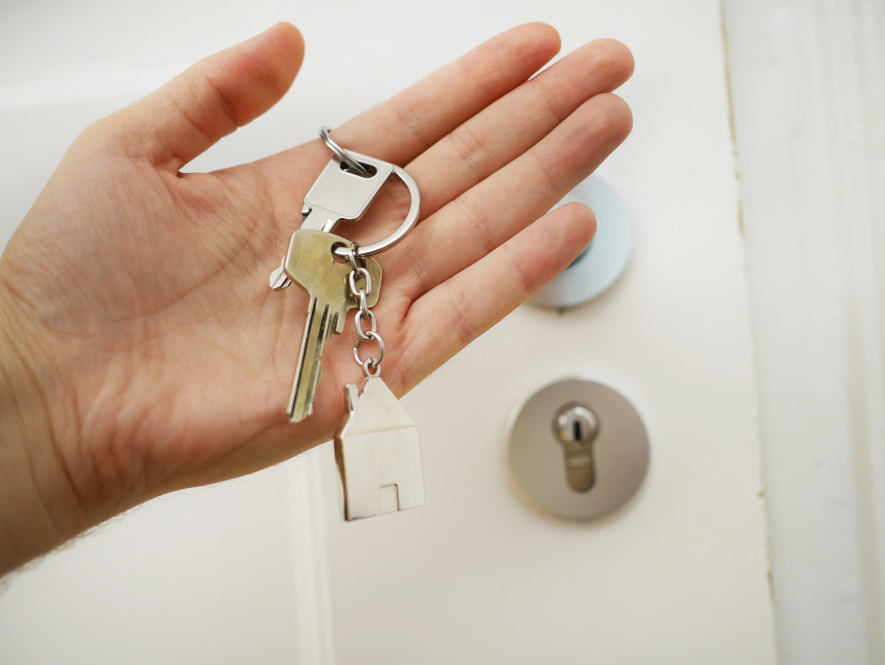 Een vrouw heeft een sleutelbos vast voor de deur van haar huis. Een vrouw heeft een sleutelbos vast voor de deur van haar huis.