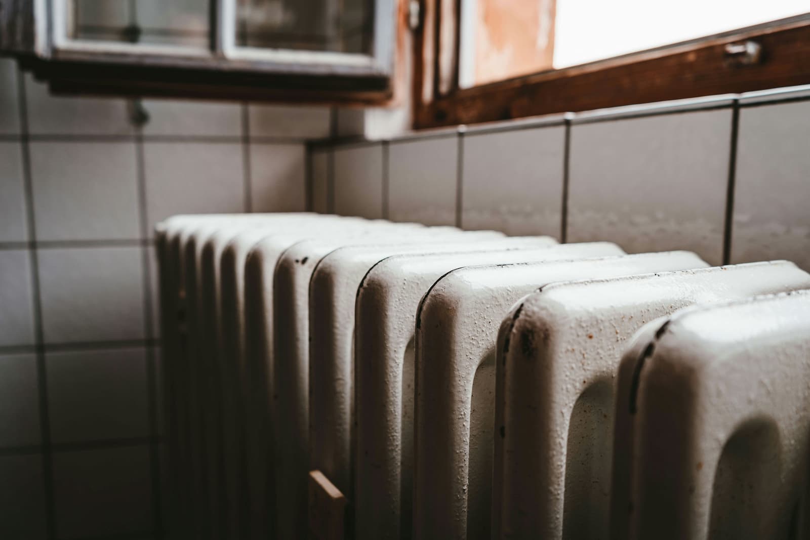 Een witte verwarming tegen een muur aan Een witte verwarming tegen een muur aan