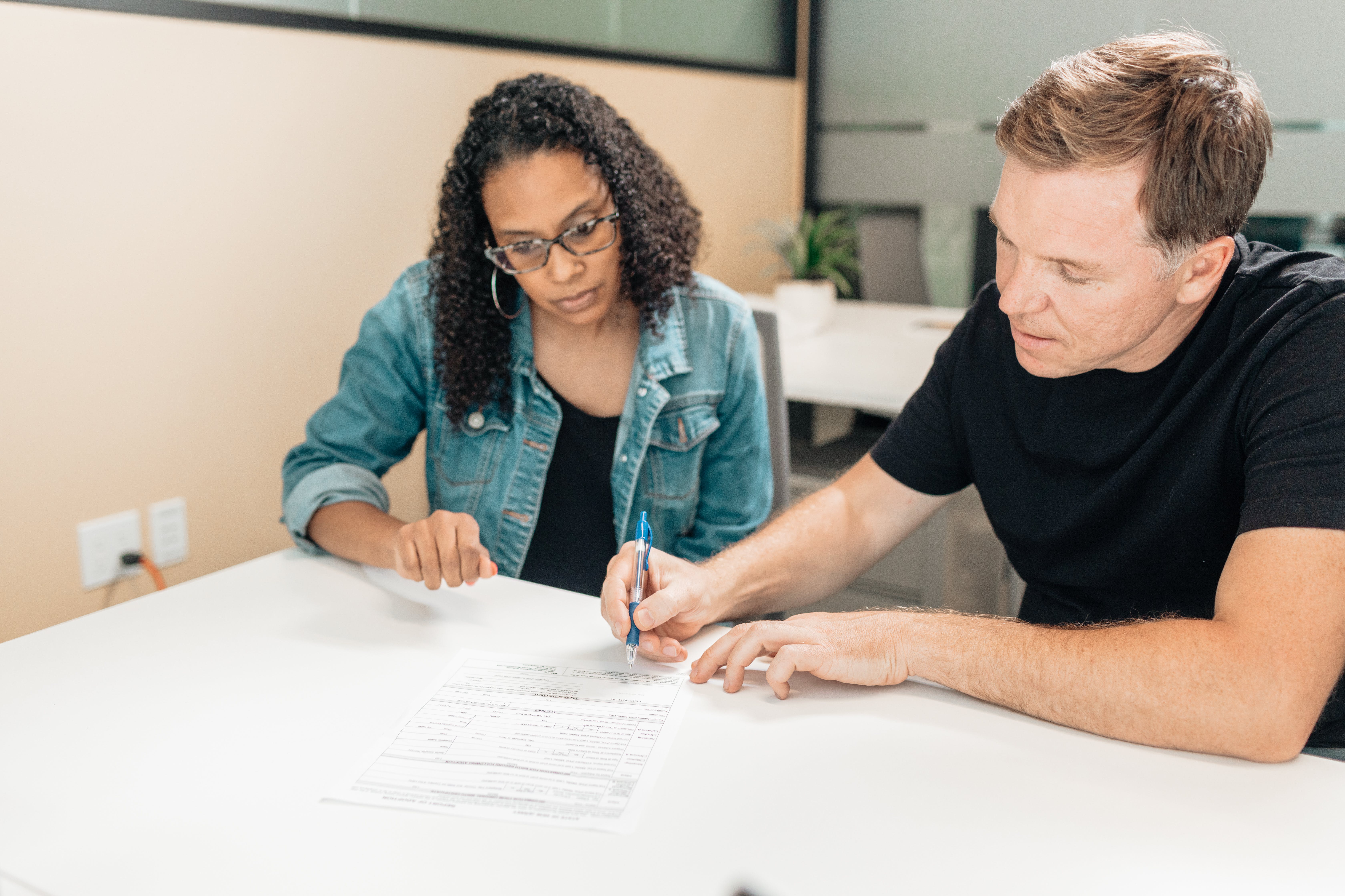 Een man en een vrouw ondertekenen een document Een man en een vrouw ondertekenen een document