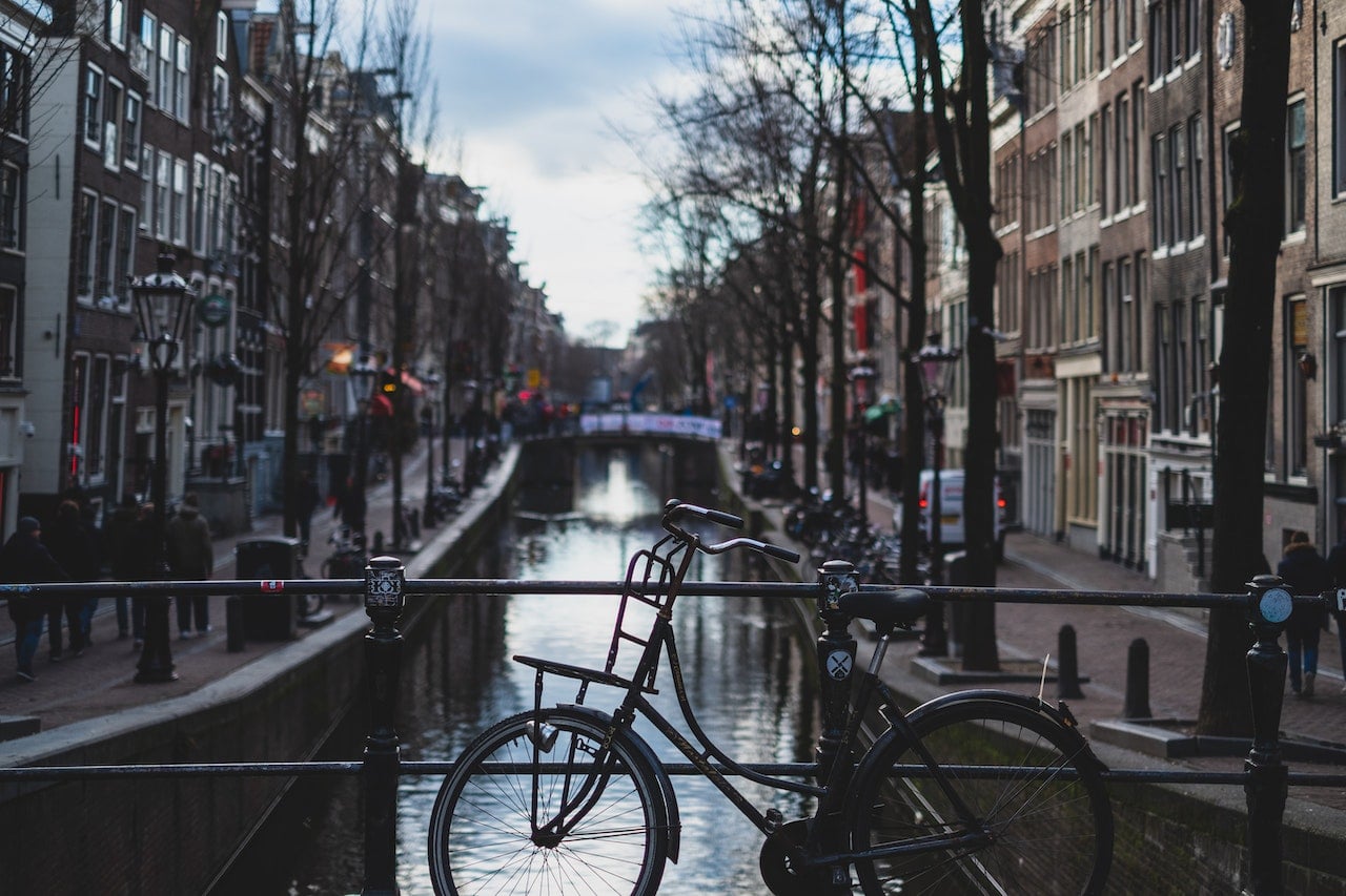 Fiets geparkeerd op een brug met Amsterdamse grachten op de achtergrond. Fiets geparkeerd op een brug met Amsterdamse grachten op de achtergrond.