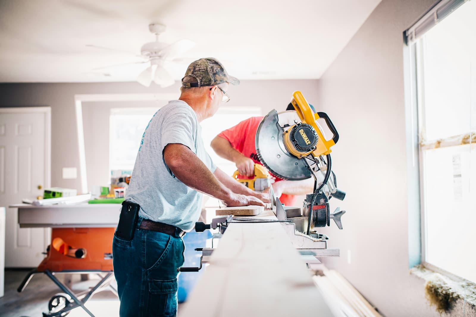 Bouwvakkers zijn hout aan het zagen tijdens een renovatie aan een huurwoning. Bouwvakkers zijn hout aan het zagen tijdens een renovatie aan een huurwoning.